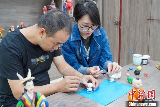 <a target='_blank'  data-cke-saved- >中新社</a>記者(右)現(xiàn)場體驗面塑制作過程。　陳爭強 攝