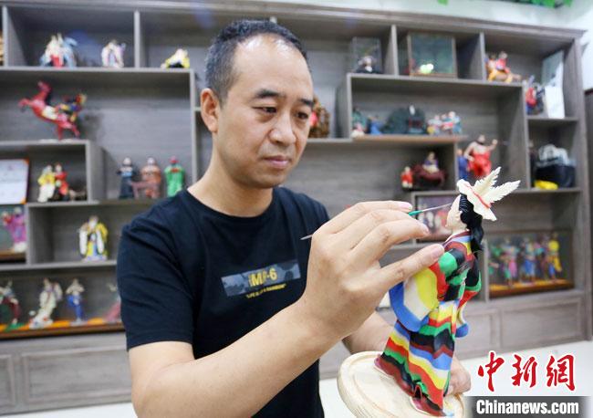 圖為安秋平正在創(chuàng)作代表隴南文縣民俗的《白馬人》作品?！「哒?攝