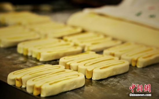 圖為面劑被涂上胡麻油，切成條狀用作月餅的花型制作。張文 攝