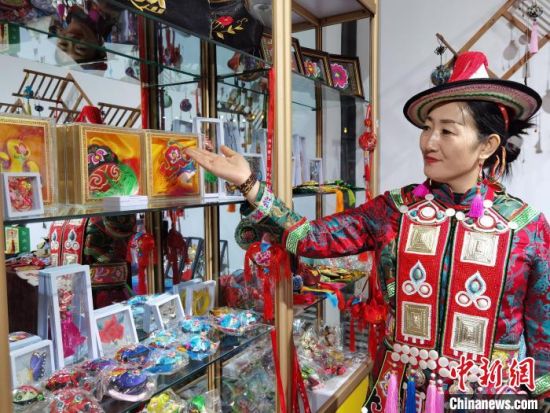圖為身著民族服飾的隴原巧手展示手工藝品。(資料圖) 徐雪 攝
