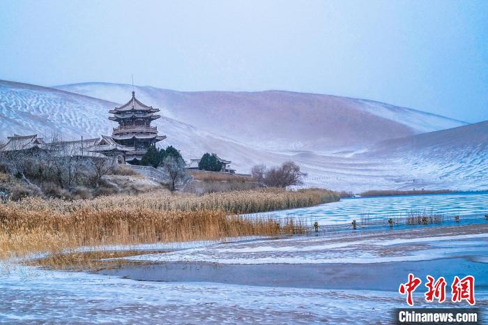 2021年11月28日，雪落鳴沙山月牙泉景區(qū)?！⊥醣筱y 攝