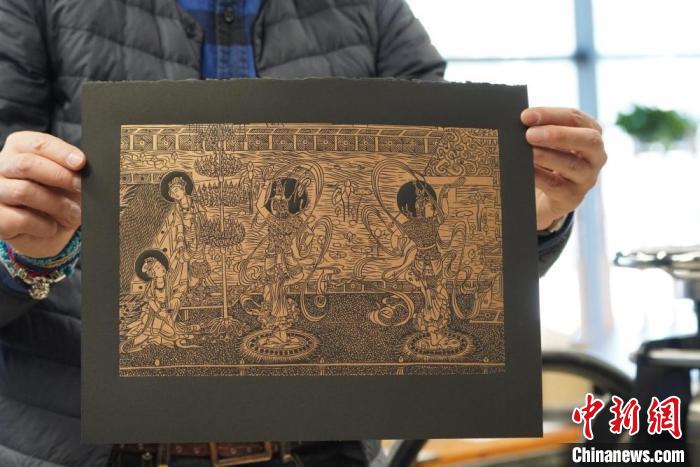圖為手工書(shū)藝人展示敦煌雕版壁畫(huà)印刷品?！【琶赖┰?　攝