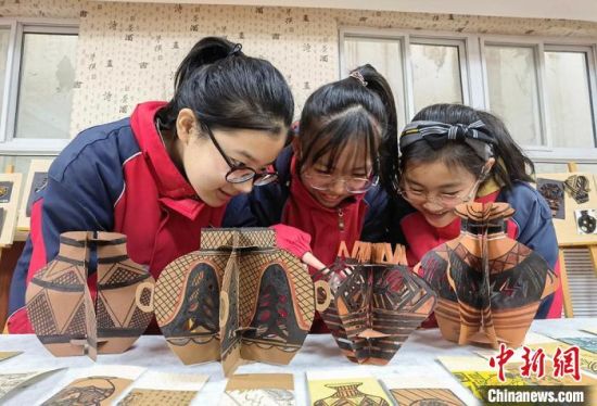 圖為學生用紙創(chuàng)作的立體彩陶?！⒂裉?攝