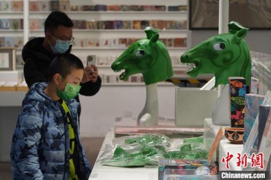 圖為“神馬來了”銅奔馬頭套吸引參觀者駐足?！【琶赖┰?攝