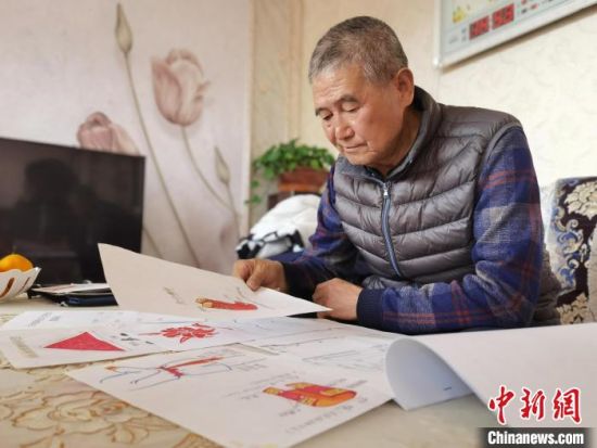 圖為陸鵬飛向記者展示多年帶隊(duì)的手寫筆記?！堟?攝