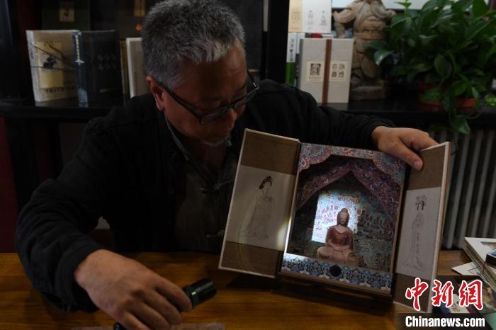 圖為讀者出版集團(tuán)讀者晉林工作室獨立出品人徐晉林，展示互動性強的敦煌題材手工書。(資料圖) 楊艷敏 攝