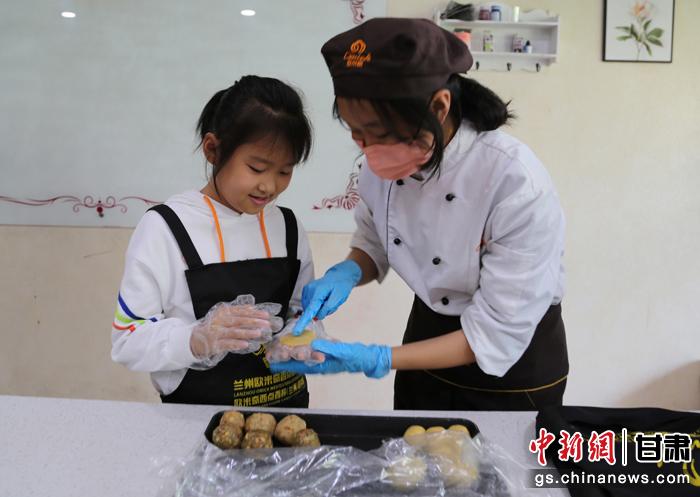 圖為在甘臺胞小朋友在工作人員指導下制作月餅。九美旦增 攝