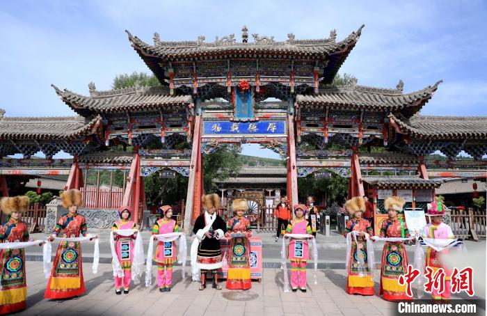 圖為身穿土族服飾的工作人員迎接訪客?！⊙Φ?攝