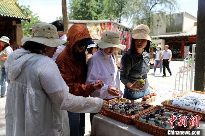 圖為民眾挑選手工藝產(chǎn)品?！⊙Φ?攝