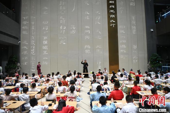 圖為9月7日，甘肅簡牘博物館開館儀式在蘭州舉行，小朋友們學(xué)習(xí)書寫簡牘中的文字?！≈行律缬浾?九美旦增 攝