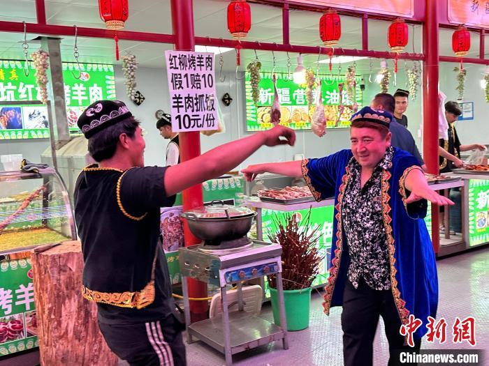 圖為餐飲經營者在“西涼不夜城”跳起舞蹈引客?！〈魑牟?攝</p><p>