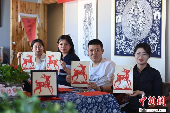 6月6日，在甘肅敦煌青年夜校課程中，青年學(xué)員展示學(xué)習(xí)敦煌非遺剪紙的成果。李亞龍 攝　　