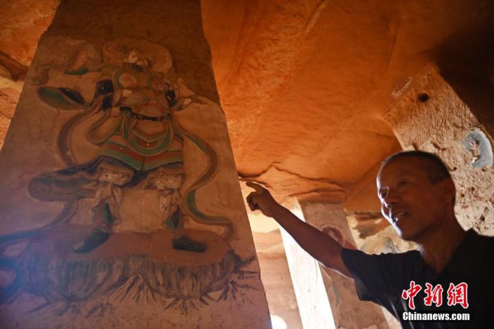 7月15日，甘肅省平?jīng)鍪袥艽h百里石窟長廊羅漢洞石窟內(nèi)，該窟文保員郭建平介紹窟內(nèi)石刻彩繪壁畫。郭建平家中三代人曾自發(fā)保護羅漢洞石窟。羅漢洞石窟遺存40余個窟龕，以北魏至清代風格為主。中新社記者 李亞龍 攝</p>
<p>