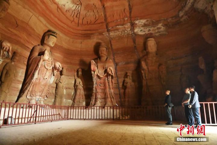 7月15日，游人參觀甘肅省平?jīng)鍪袥艽h百里石窟長廊中的南石窟寺1號窟。百里石窟長廊位于涇川縣境內(nèi)，由512個石窟、5眼窟中石井組成，現(xiàn)存王母宮石窟、鳳凰山石窟、南石窟寺、丈八寺石窟、羅漢洞石窟、太山寺石窟等規(guī)模較大的石窟群，還有數(shù)量眾多的小石窟群。南石窟寺開鑿于北魏永平三年，其中1號窟屬于大型七佛窟，七佛高達6米。中新社記者 李亞龍 攝