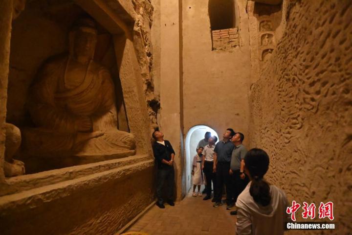 7月15日，游人參觀甘肅省平?jīng)鍪袥艽h百里石窟長廊中的王母宮石窟。百里石窟長廊位于涇川縣境內(nèi)，由512個石窟、5眼窟中石井組成，現(xiàn)存王母宮石窟、鳳凰山石窟、南石窟寺、丈八寺石窟、羅漢洞石窟、太山寺石窟等規(guī)模較大的石窟群，還有數(shù)量眾多的小石窟群。王母宮石窟又名千佛洞，該窟設計宏大，造像生動，窟內(nèi)擁有造像數(shù)百尊，是較為珍貴的佛教文化歷史遺存。中新社記者 李亞龍 攝</p>
<p>