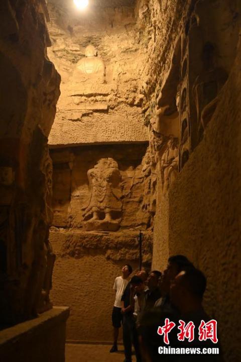 7月15日，游人參觀甘肅省平?jīng)鍪袥艽h百里石窟長廊中的王母宮石窟。百里石窟長廊位于涇川縣境內(nèi)，由512個石窟、5眼窟中石井組成，現(xiàn)存王母宮石窟、鳳凰山石窟、南石窟寺、丈八寺石窟、羅漢洞石窟、太山寺石窟等規(guī)模較大的石窟群，還有數(shù)量眾多的小石窟群。王母宮石窟又名千佛洞，該窟設計宏大，造像生動，窟內(nèi)擁有造像數(shù)百尊，是較為珍貴的佛教文化遺存。中新社記者 李亞龍 攝</p>
<p>
