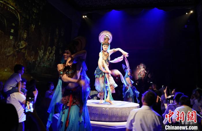 《樂動敦煌》是全球首部洞窟式沉浸體驗劇，利用真人與數(shù)字影像虛實交換實現(xiàn)沉浸式體驗。圖為2023年8月28日晚，《樂動敦煌》演出。(資料圖)中新社記者 毛建軍 攝